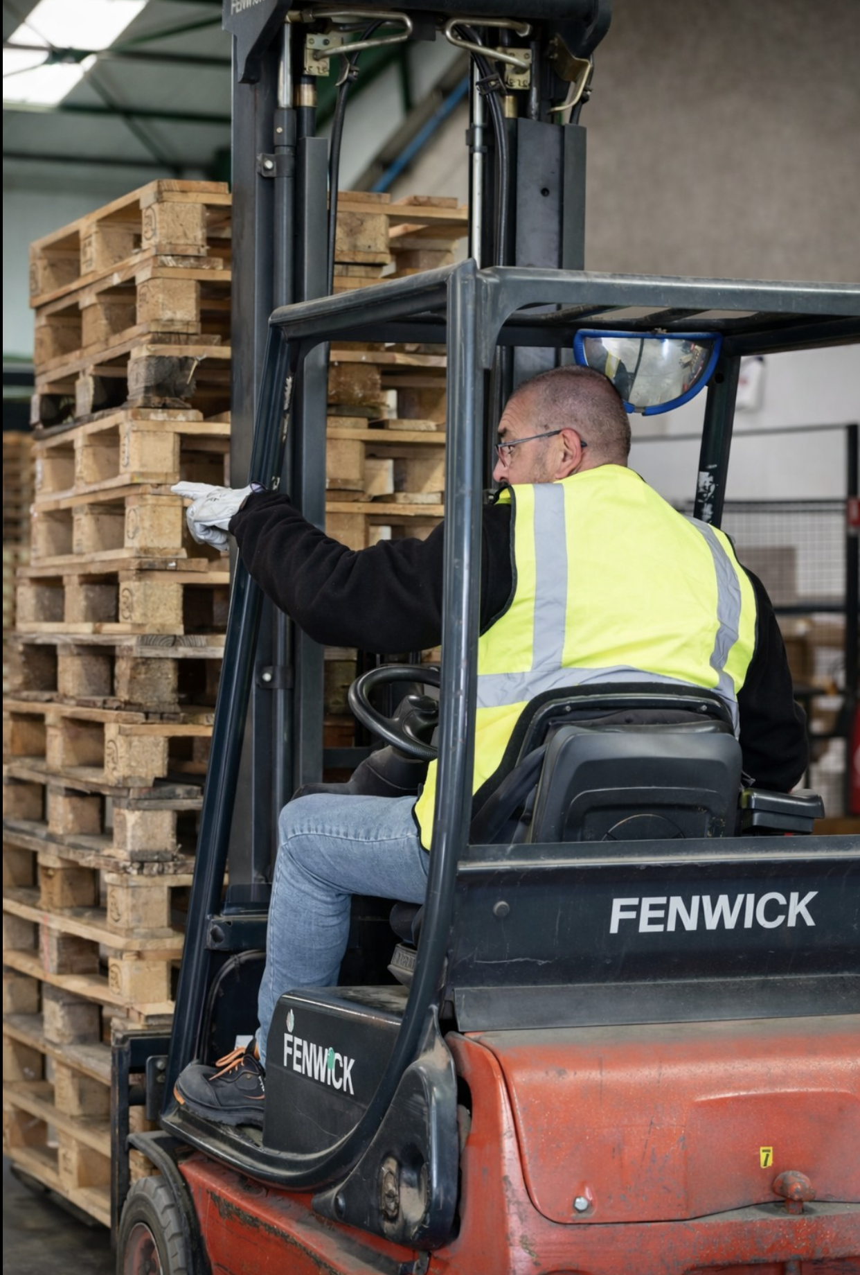 Préparation logistique et manutention – Van de Walle Cariste manipulant des palettes avec un chariot élévateur dans un entrepôt logistique.
